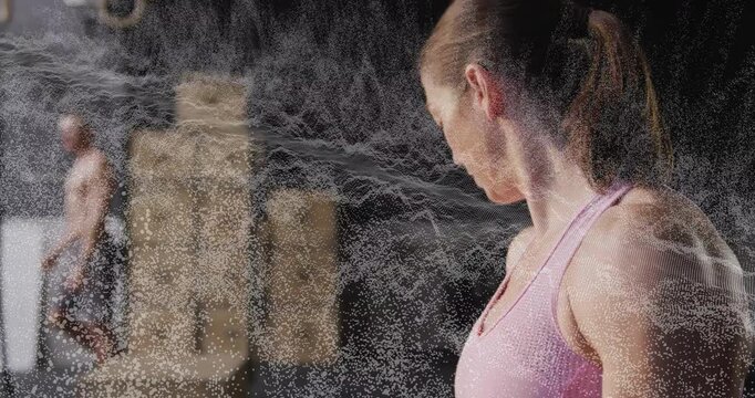 Fitness-focused lifter rubbing chalk on palms creating dust cloud with mesh-effect for lift prep