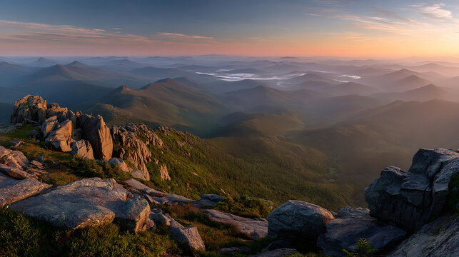 Majestic mountain range at sunrise with rocky foreground and misty valleys panoramic landscape
