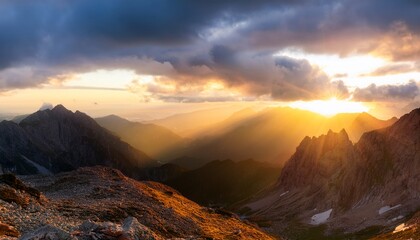 dramatic sunrise over majestic mountain peaks with golden rays illuminating the sky
