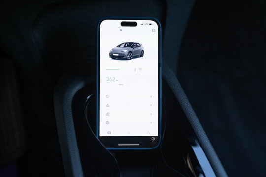 Smart phone with application for electric vehicles. controlling electric car charging level via mobile app. Car status information on the mobile app. Concept of modern and smart technologies