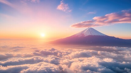 Fototapeta premium Snow capped mountain peak above clouds at sunrise or sunset with colorful sky and horizon
