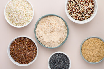 Assortment of superfoods, seeds, grains in bowls on light background. Amaranth, sesame, flaxseed, poppy, quinoa