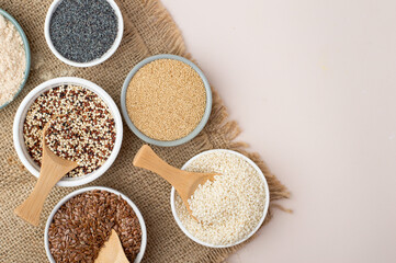 Assortment of superfoods, seeds, grains in bowls on light background. Amaranth, sesame, flaxseed, poppy, quinoa. Top view
