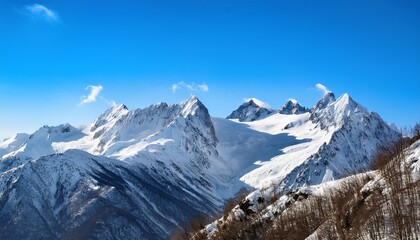 towering snowy mountains under bright blue sky in winter landscape