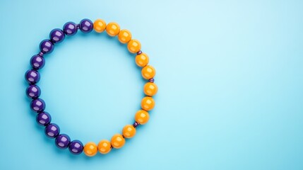 Obraz premium Vibrant purple and orange beaded circle arrangement on light blue background festive decorative object design