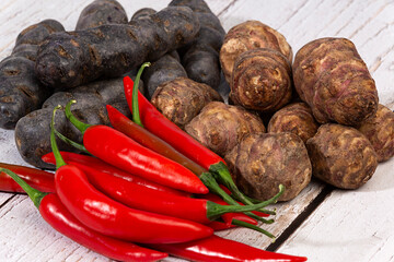 Guindillas rojas, patatas moradas y tupinambos.