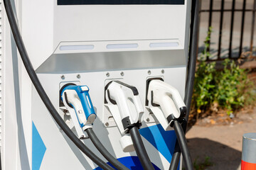 Modern charging station for electric vehicles with three connectors, providing fast and convenient charging. Suitable for urban conditions and travel.