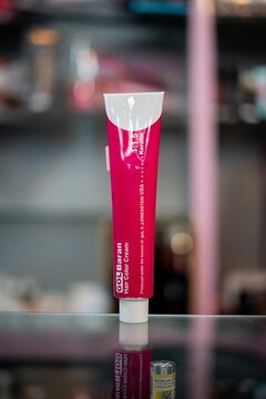 Amsterdam, Netherlands april 10, 2025. baran hair color cream in a bright pink tube, standing upright on a reflective surface. Designed for vibrant, long-lasting hair color, enriched with
