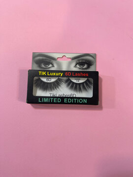 Amsterdam, Netherlands april10,2025. Close-up of TIK Luxury 6D Lashes in black packaging with eye graphic. Set against soft pink background, perfect for promoting high-quality synthetic eyelash