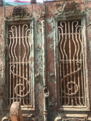 Antique Wooden Doors with Metal Grilles and Weathered Turquoise Paint