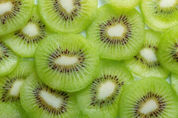 Close-up shot of numerous bright green kiwi fruit slices, meticulously arranged to form a vibrant, textured background. 