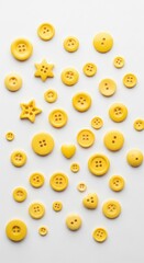 yellow buttons in various shapes and sizes scattered on a solid white background