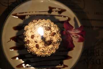 Latina woman celebrating her birthday with a small personal size chocolate cake with a candle 