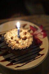Latina woman celebrating her birthday with a small personal size chocolate cake with a candle 