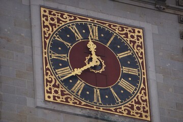 Close up of the historic clock on the Rathaus tower of the landmark Hamburg city hall, with its ornate golden dial and iconic Roman numerals