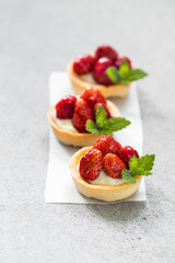 Vegan Round Strawberry tartlet. Light gray background. Close up