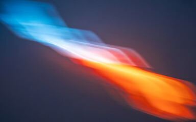 Obraz premium Abstract blue and orange light streaks on dark background