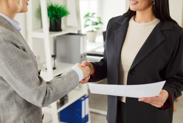 Women handshaking close up, making business agreement, partnership after negotiations in office, female hr manager greeting job seeker after interview, client customer making offer of employment