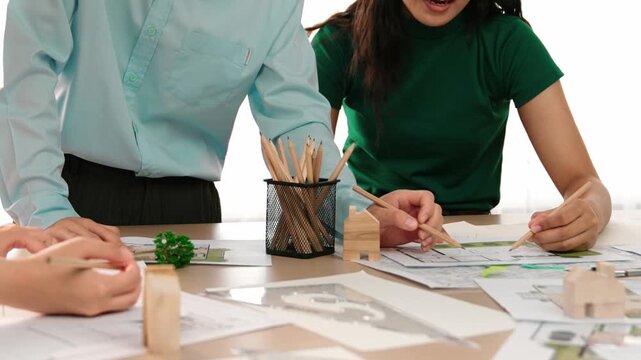 A video of architect use measurement tools and pencil to measure blueprint. Architect design house construction on a table at studio, with architectural plan scattered around. Focus hand. Delineation.