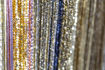 Colorful strands of shimmering metallic ribbons hanging together in a vibrant display of textures