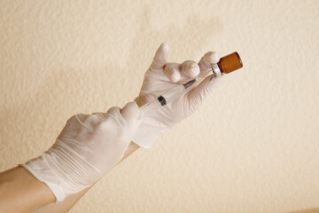 Medical professional preparing vaccine syringe from amber vial in sterile environment
