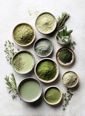 Assorted green powders and herbs in small bowls on a light background, showcasing various shades and textures