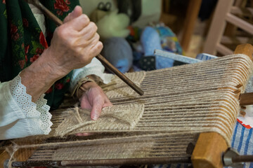 Skilled artisan weaving fabric on traditional loom with natural fibers and intricate patterns