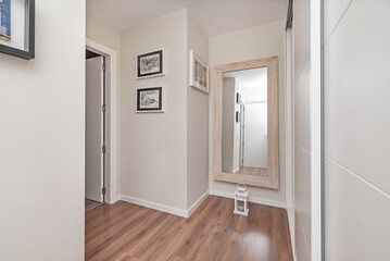Scandinavian design in a bedroom with a clean-lined white wardrobe and side coat racks for added practicality