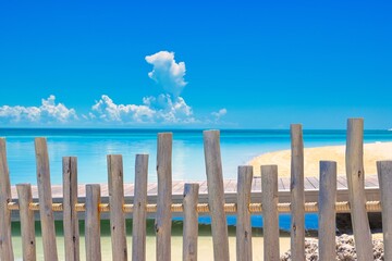 A  weathered wood fence blocking pff two beaches.