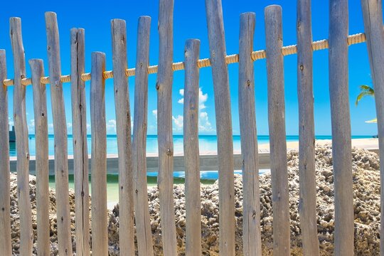 A  weathered wood fence blocking pff two beaches.
