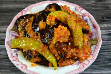 A plate of Pickled roast fried aubergine and green peppers stuffed with garlic, chili red pepper,vinegar, lemon, coriander, parsley, chopped tomatoes and spices, marinated Egyptian eggplant pickles