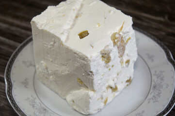 White Feta cheese with slices of olive, Feta is a Greek brined white cheese made from sheep milk or from a mixture of sheep and goat milk, soft, with small or no holes, and no skin, crumbly and grainy