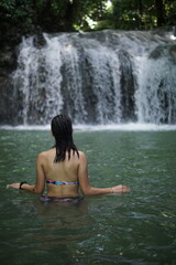 Fototapeta premium Female tourists exploring Siete Altares, which is a natural attraction located near Livingston, Guatemala, featuring seven freshwater pools and waterfalls set within a lush rainforest.