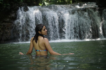 Female tourists exploring Siete Altares, which is a natural attraction located near Livingston, Guatemala, featuring seven freshwater pools and waterfalls set within a lush rainforest.