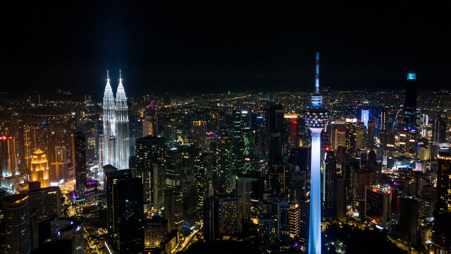 Aerial view of the Petronas Twin Towers and KL Tower piercing the night sky, a symphony of illuminated skyscrapers, Kuala Lumpur, Federal Territory of Kuala Lumpur, Malaysia.