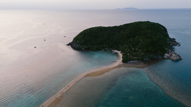 Aerial view of a sandy isthmus connecting a verdant island to the mainland, embraced by the turquoise sea, Ko Ma Beach, Koh Phangan, Thailand.