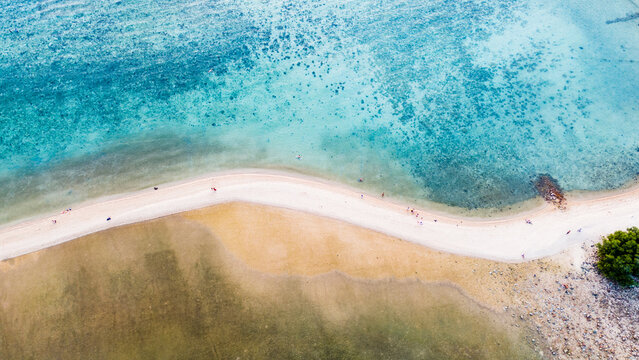 Aerial view of a sandy strip kissed by turquoise waters, a natural bridge where the sea's embrace meets the shore's gentle curve, Ko Ma Beach, Ko Pha-ngan, Surat Thani, Thailand.