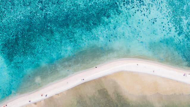 Aerial view of sun-kissed sandbar curves gracefully between the turquoise and azure waters, a tranquil paradise, Ko Ma Beach, Surat Thani, Thailand.