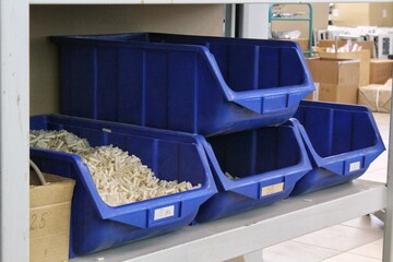 Blue Plastic Storage Bins on Metal Shelf. Several Blue Bins for Parts Organization. Plastic Containers for Storage on Shelving. Blue Industrial Storage Bin Arrangement. Blue Plastic Bins for Inventory