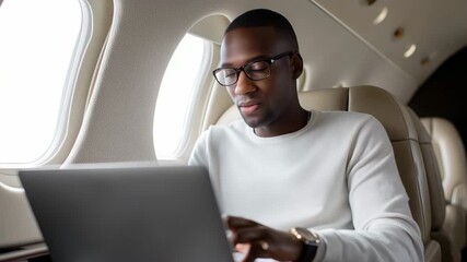 Businessman working on laptop during flight inside private jet cabin - Powered by Adobe