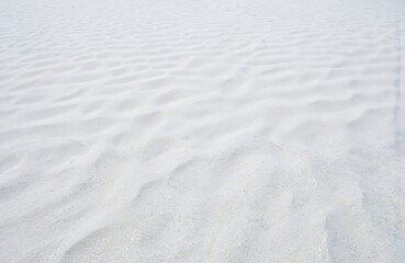 Obraz premium Close-up of rippled white sand dunes creates serene, natural pattern. Fine grained texture resembles desert landscape tranquil Japanese garden. Ideal for themes of balance, summer holidays, zen.