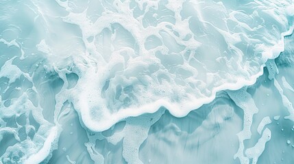 Obraz premium Waves crash against a rocky shoreline, creating a dynamic and foamy display of turquoise water and white foam.
