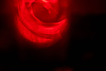 Red color light leaks on dark black background. Design and special effect. Random shapes and tone.