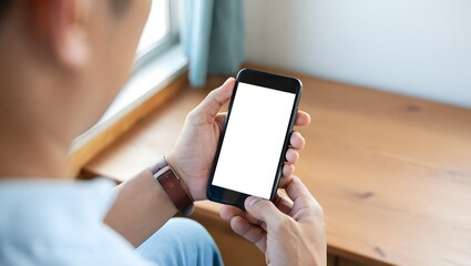 Mockup, woman's hands holding mobile phone with blank screen in coffee shop. Woman using smartphone, looking at the screen, over shoulder view