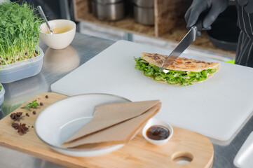 The chef prepares a flatbread with herbs. 