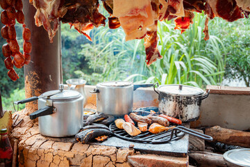 Rustic Wood-Fired Outdoor Cooking with Smoked Meats and Stew Pots