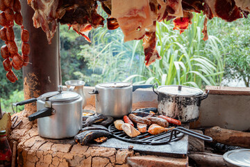 Authentic Rural Cooking Scene with Smoked Meats and Firewood Stove