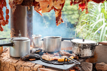 Close-Up of Wood-Fired Stove with Pots and Grilled Meats in Rustic Outdoor Kitchen