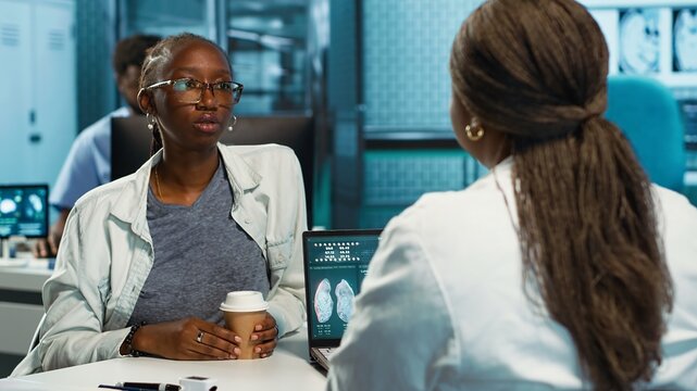 African american girl with bronchitis and a sore throat discuss with medic at the facility, uncomfortable laryngitis inflammation. Physician treating an unhealthy patient with pain. Camera A.
