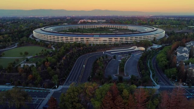 Aerial view of Apple Park, the corporate headquarters of Apple, surrounded by trees and buildings in Cupertino, California, USA.  